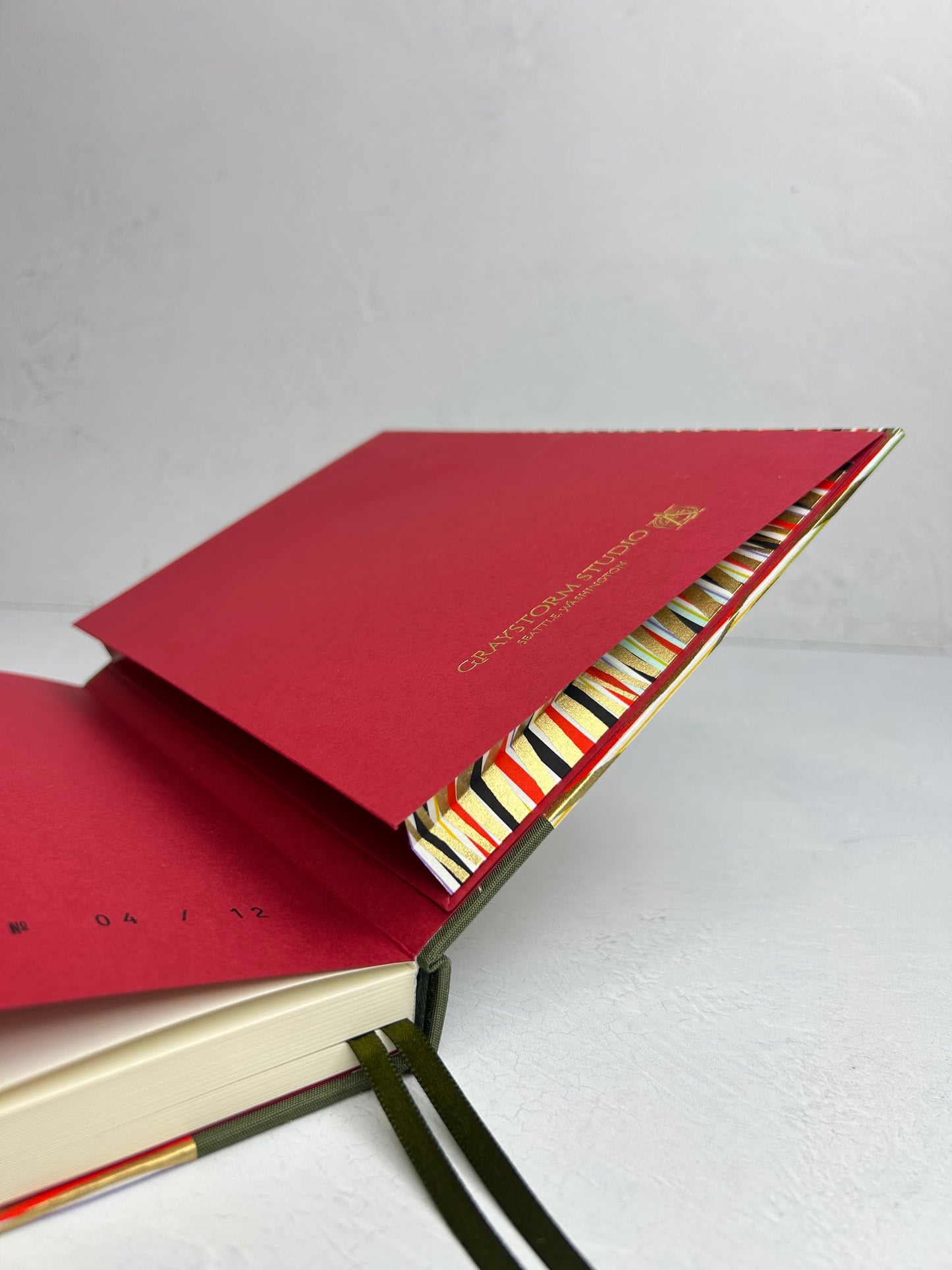 A5 160-page Hardcover Journal finished in olive green Japanese book cloth and gold, black and red geometric Chiyogami Paper