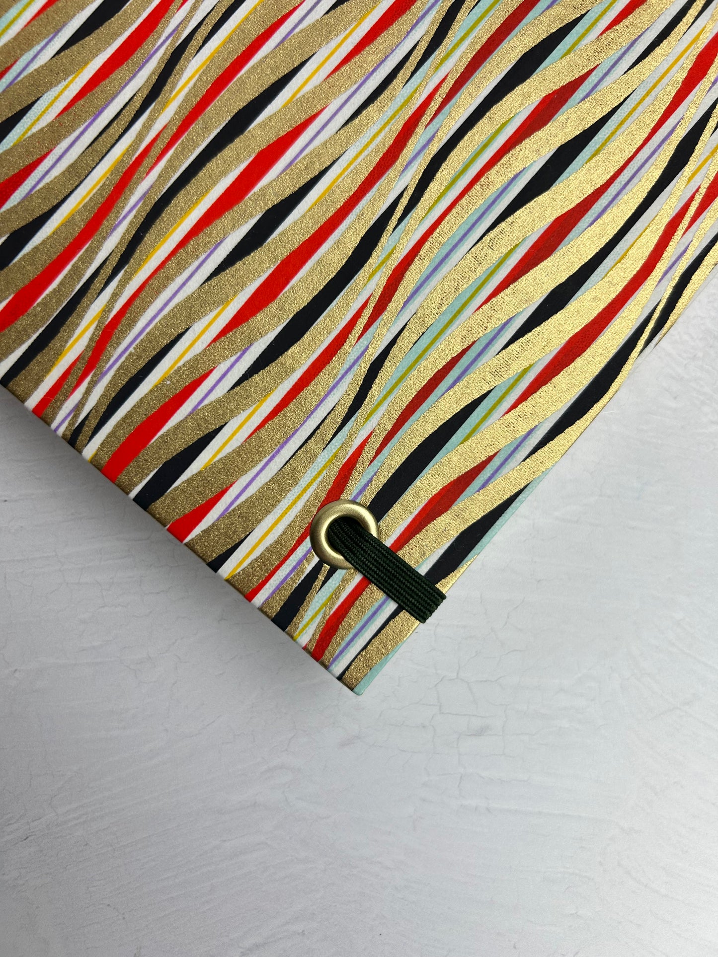 A5 160-page Hardcover Journal finished in olive green Japanese book cloth and gold, black and red geometric Chiyogami Paper