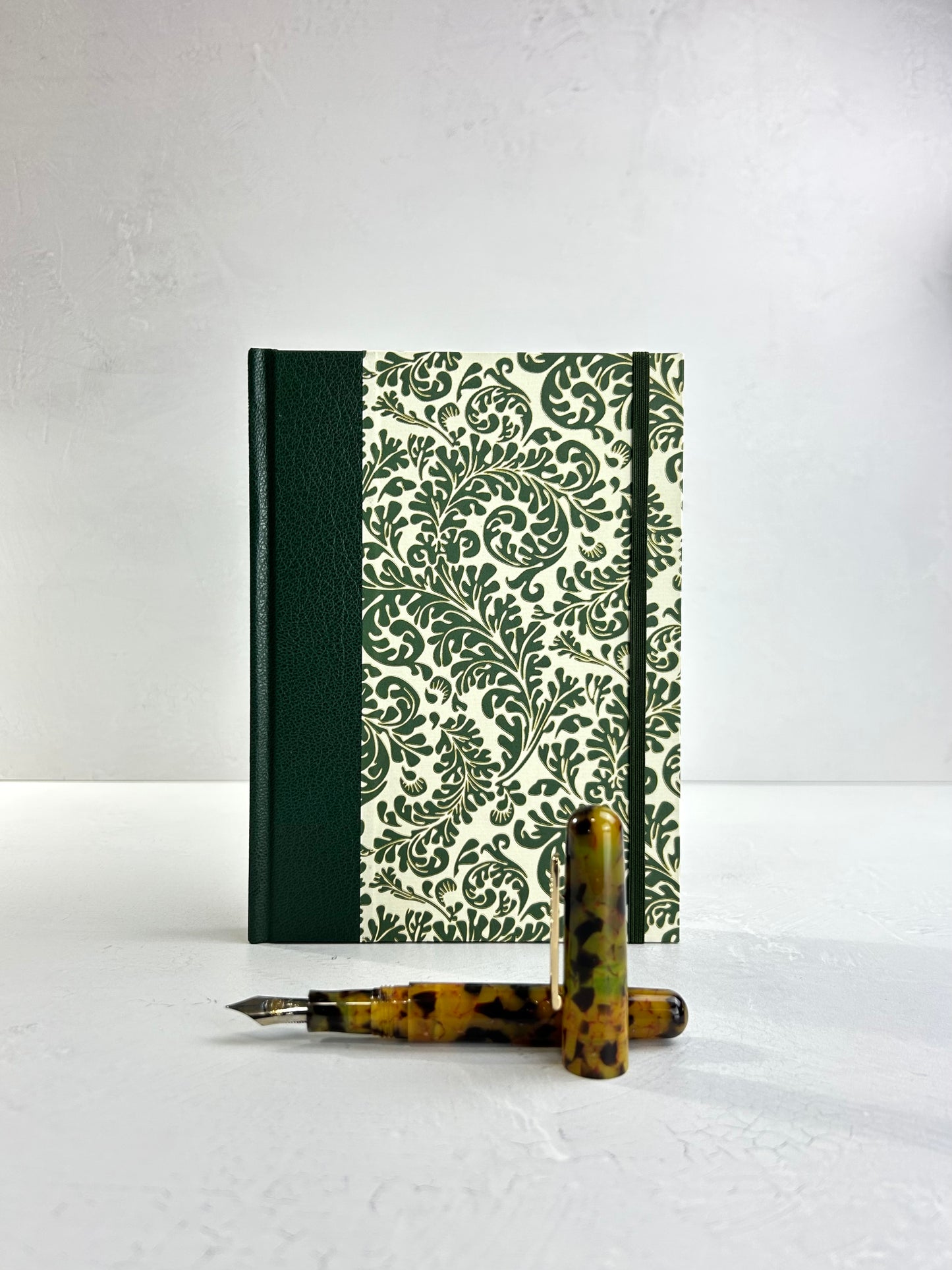 A5 160-page Hardcover Journal finished in Green Vaux Leather and green and gold fern Italian Florentine print