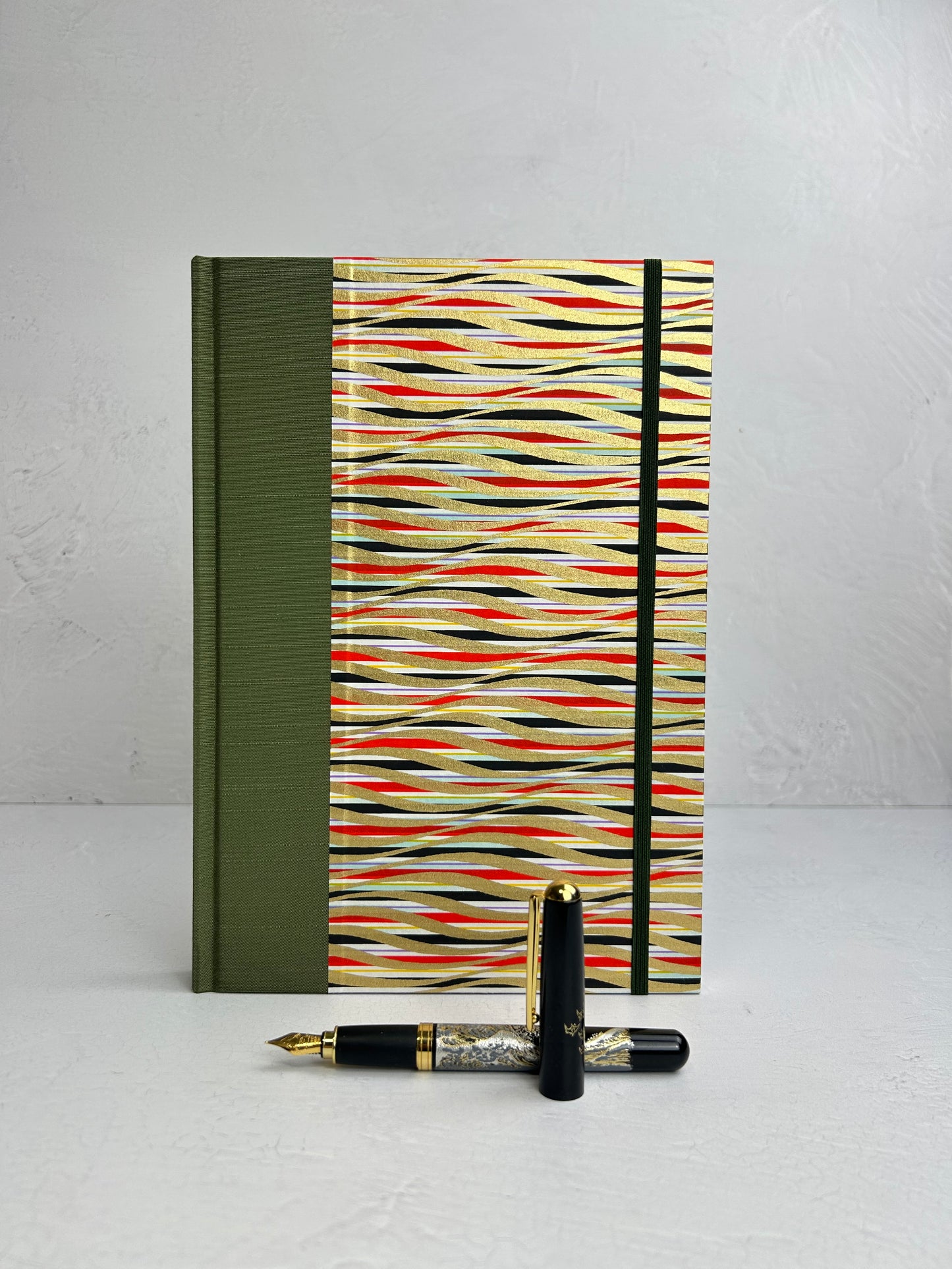 B5 192-page Hardcover Journal finished in olive green Japanese book cloth and gold, black and red geometric Chiyogami Paper