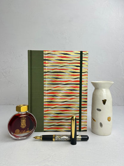A5 160-page Hardcover Journal finished in olive green Japanese book cloth and gold, black and red geometric Chiyogami Paper