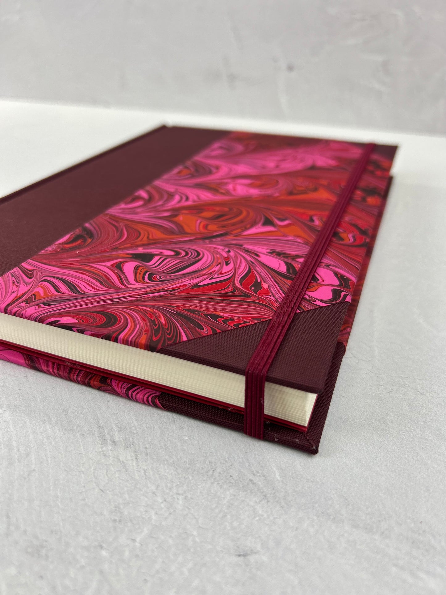 B5 192-page Hardcover Journal finished in Maroon Japanese book cloth and red/pink hand marbled paper by Daniel Gaál