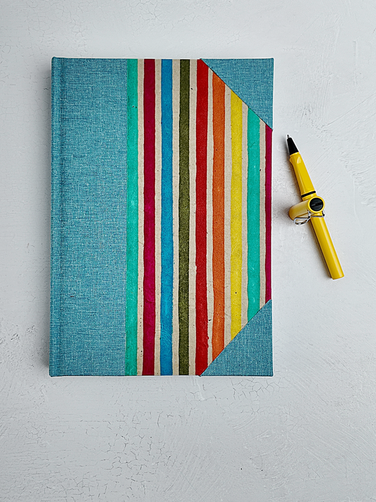 B5 192-page Hardcover Journal finished in Light Blue Verona book cloth and rainbow Lokta Paper
