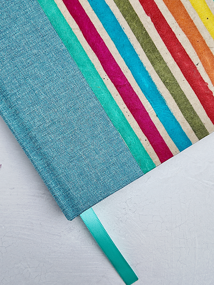 B5 192-page Hardcover Journal finished in Light Blue Verona book cloth and rainbow Lokta Paper