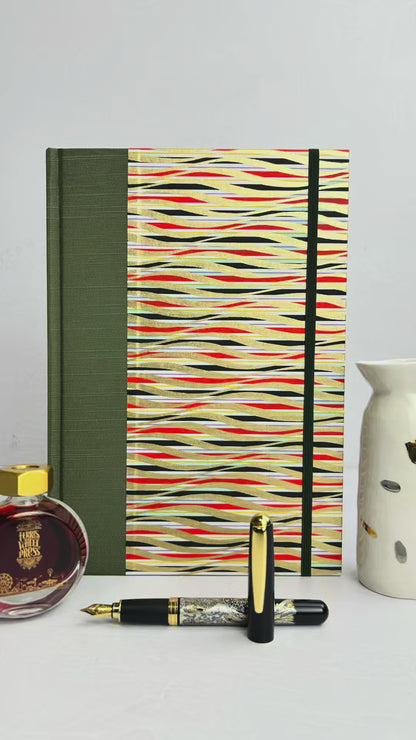 A5 160-page Hardcover Journal finished in olive green Japanese book cloth and gold, black and red geometric Chiyogami Paper